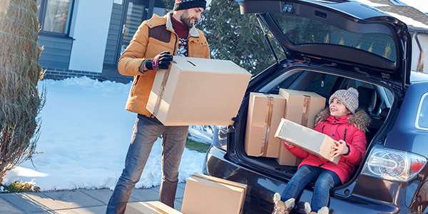 Dad and daughter unloading boxes from their car during their winter move.